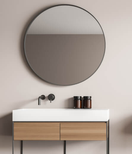 home care supply bathroom with a round mirror and wooden sink